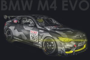 Ein dunkelgrauer BMW M4 EVO mit gelben Akzenten und der Startnummer 169 steht in auffälliger Rennlackierung.