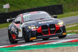 Schwarzer BMW Rennwagen mit rotem und grauem Sonic Branding, der auf einer Rennstrecke fährt.