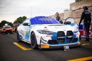 BMW Rennwagen mit blauer und weißer Lackierung und Startnummer 22 auf einer Rennstrecke.