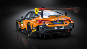 Heckansicht des orange-schwarzen BMW M4 GT3 von FK Performance Motorsport, zeigt Heckflügel und Diffusor.