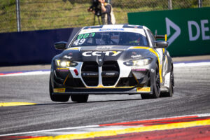 Frontalansicht des BMW M4 GT4 (Startnummer 49) mit CCTY-Sponsoring auf der Rennstrecke beim Überfahren der Curbs.