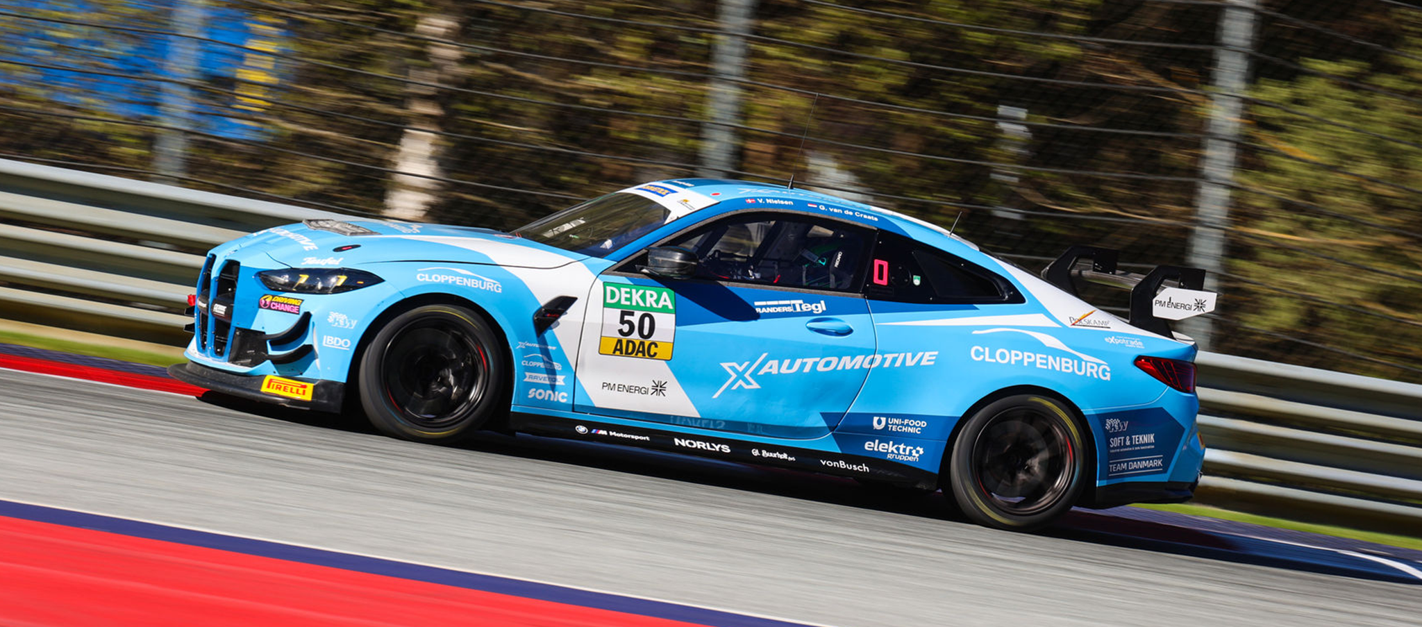 Seitliche Profilansicht des hellblauen BMW M4 GT4 im X-Automotive-Design während einer schnellen Fahrt auf der Strecke.